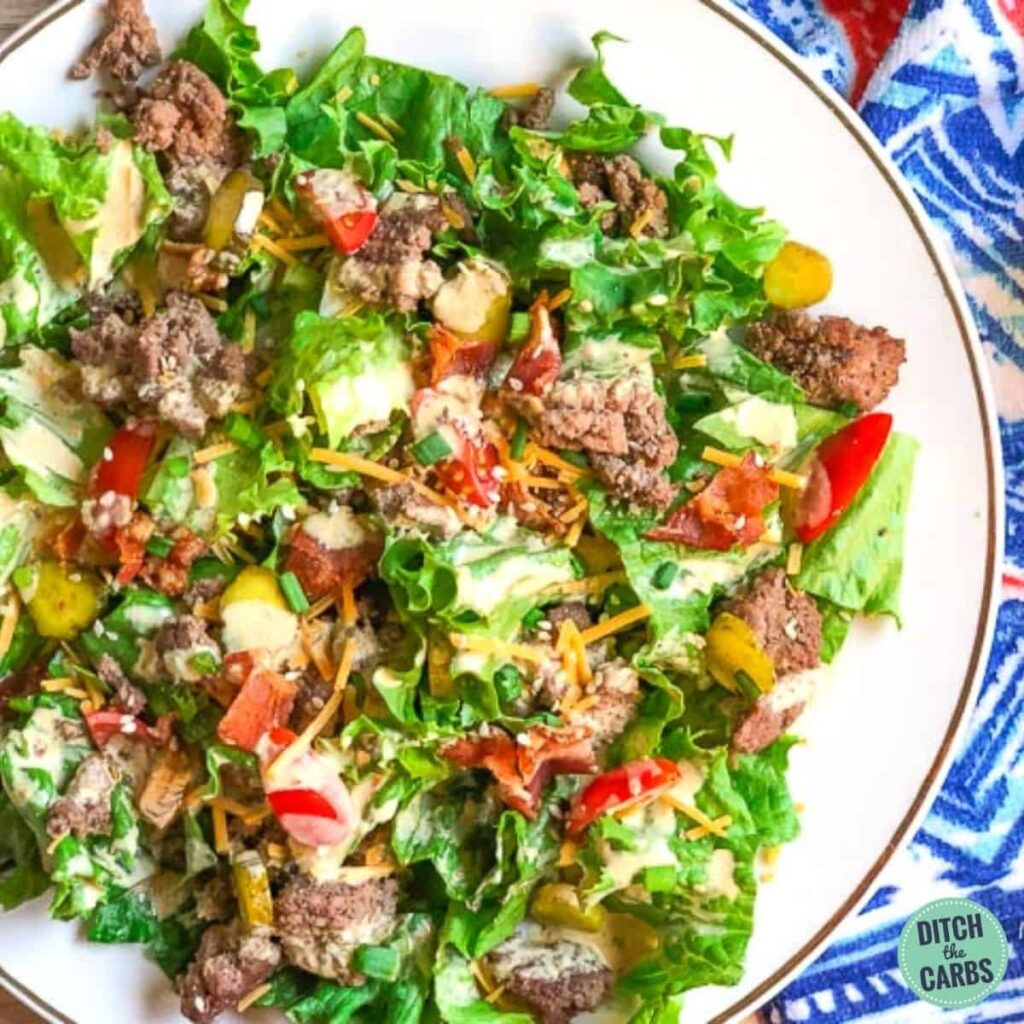 keto hamburger salad on a white plate and blue cloth