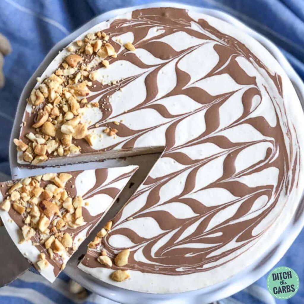 A slice of chocolate peanut butter cheesecake on a small cream and golden plate