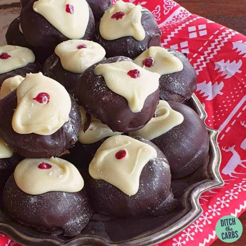 homemade keto sugar-free marzipan balls dipped in chocolate on a silver plate