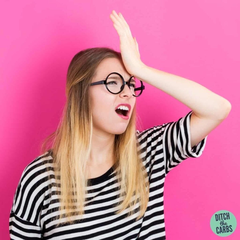 women holding head in hands laughing
