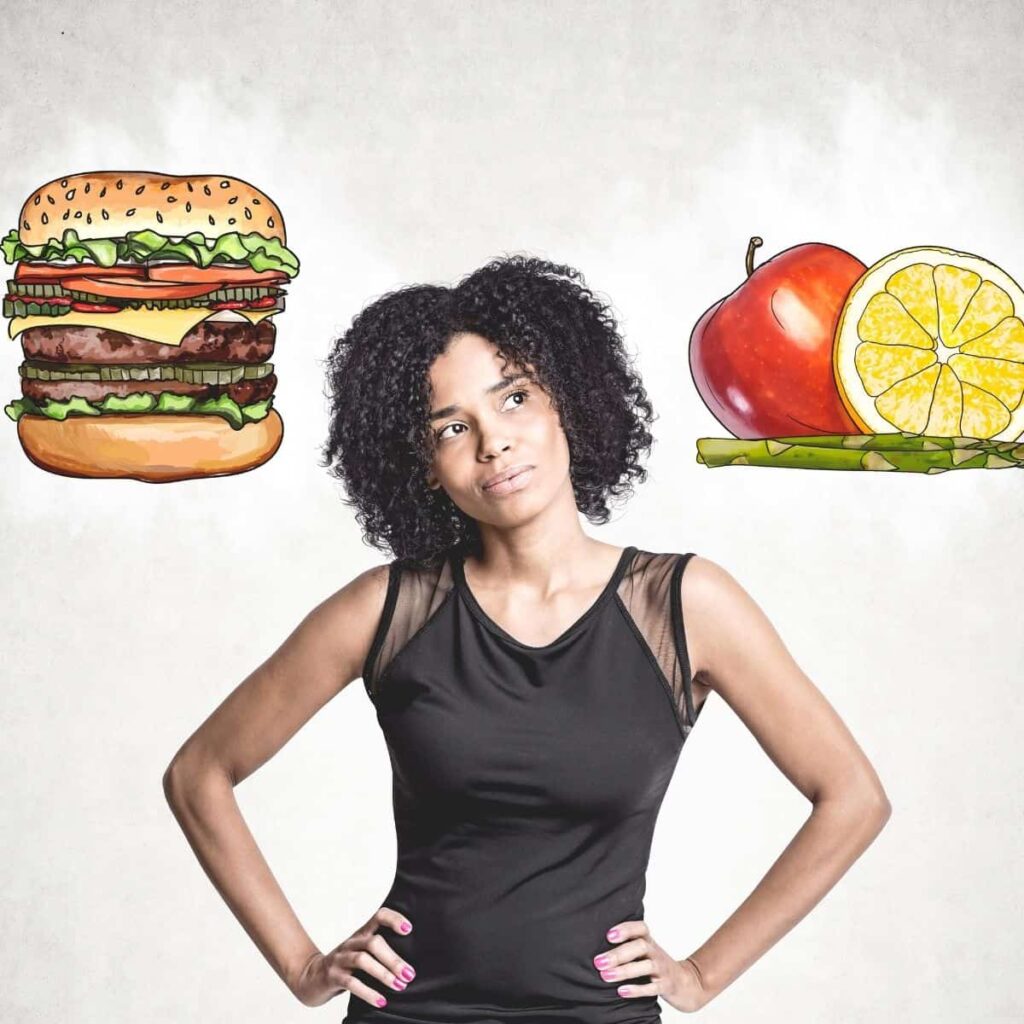 a woman in a black top with a burger and an apple in the air